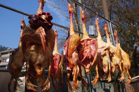 The suspended pieces of the meat drying outside on the sunの写真素材