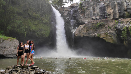 BALI, INDONESIA- 14 FEB, 2019: Young beautiful tourist visiting the Tegenungan waterfall in Bali, Indonesiaのeditorial素材