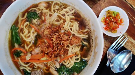 Traditional Indonesian meal soup noodle with vegetables and chicken in bowl