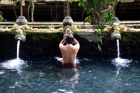 Praying in holy spring water of sacred pool at Pura Tirta Empul Templeのeditorial素材