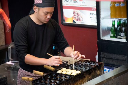 Osaka, Japan- 02 Dec, 2019: Process to cook Takoyaki on hot pan. Famous food Osaka Japan street food.のeditorial素材