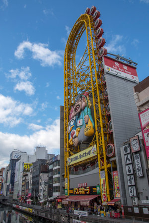 Osaka, Japan- 03 Dec, 2019: Ferris wheel on the banks of the Dotonbori Canal. Dotonbori area is very popular among tourists and localsのeditorial素材