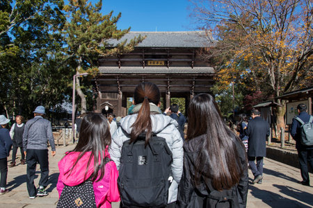 Nara, Japan- 27 Nov, 2019: Tourists walking in entrance of Todaiji Nandaimon giant temple door in Nara. Nandaimon Gate is Japan's largest temple gate, made to compliment the size of the Great Buddha Hall.のeditorial素材