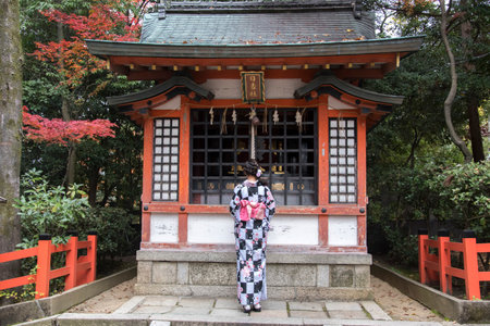 Kyoto, Japan- 27 Nov, 2019: Woman in kimono pulling the bell-rope as a sign of devotion at the Yasaka jinja shrine in Kyoto.のeditorial素材