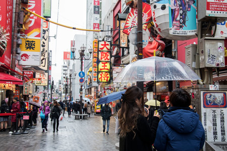 Osaka, Japan- 28 Nov, 2019: People visit Dotonbori street in Osaka during raining day. Dotonbori is the main entertainment area of Osaka.のeditorial素材