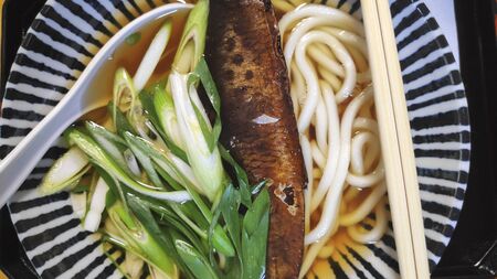 Broth with udon noodles and herring, Japanese mealの写真素材