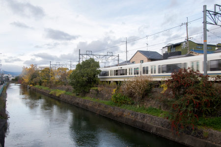 Kyoto, Japan- 26 Nov, 2019: Japanese train travel along the river in Kyoto. Japan is covered by an...