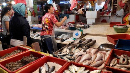 Singapore- 01 Mar, 2020: Customers buy fresh fish from a stall in a wet market in Singapore. The traditional Asian wet market still exist in this modern city.のeditorial素材
