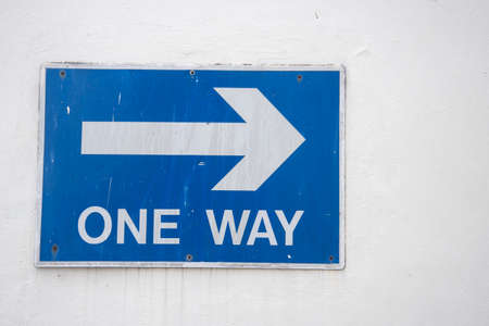One way right arrow sign on the wall. White on blue backgroundの写真素材