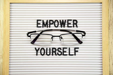 Empower Yourself text with black eye glasses. Top viewの写真素材