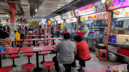 Singapore- 11 Oct, 2021: People enjoying food at the hawker center in Singapore. Hawker centre or cooked food centre is an open-air complex in Singaporeのeditorial素材