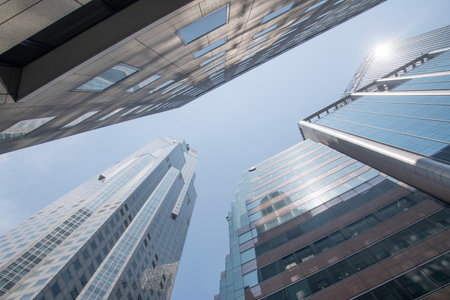 Singapore- Mar 26, 2020: Glass-clad facade of a modern building covered in reflective plate glass with blue skyのeditorial素材