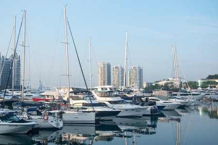 Singapore- Apr 2, 2022: Modern yachts park around Sentosa Cove along with luxury mansions. Sentosa...