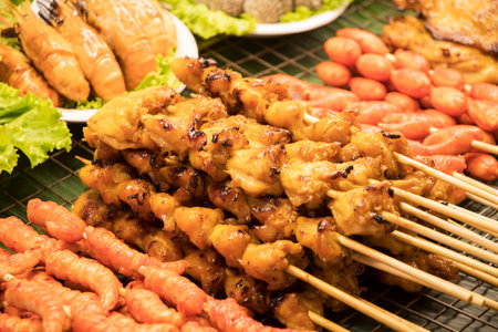 Street food market with grilled skewers food. BBQ chicken buttの写真素材