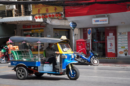 Bangkok, Thailand- 14 Feb, 2023: Traditional tuk-tuk travels on the road in Bangkok. Tuk tuks are motorized 3-wheeled rickshaws that ferry passengers aroundのeditorial素材