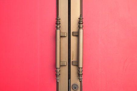 Metal door handle on red door. Close conditionの写真素材