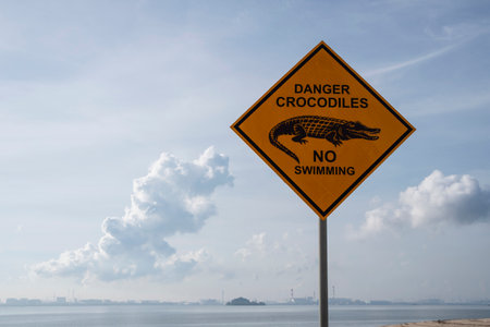Danger of crocodile warning sign on the beach in sunny dayの写真素材