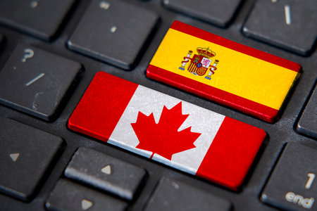 Canada and Spain flags on computer keyboard. Relationship between two countries.の写真素材