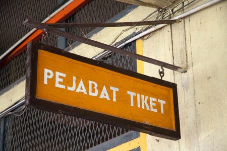 Kluang, Malaysia- 6-Oct, 2023: Yellow banner with ticketing office word hang on the wall of train station in Kluang.のeditorial素材