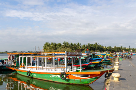 Hoi An, Vietnam- 1 Mar, 2024: Boats used to ferry tourist park along the river in Hoi An, Vietnam. Hoi An is the World Cultural heritage site, famous for mixed cultures and architecture.のeditorial素材