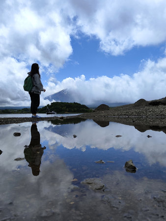 Kawaguchiko, Japan- 16 May, 2024: Reflection of tourist on Lake Kawaguchiko while looking toward Mount Fuji.のeditorial素材