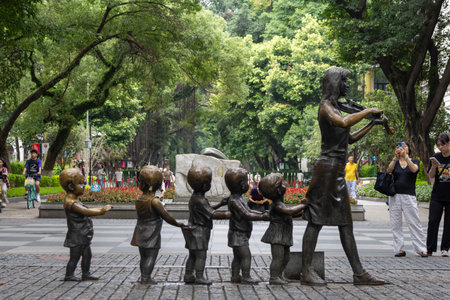 Guangzhou, China- 6 Jun 2024: Bronze sculpture of a Chinese woman walking and playing violin with six children - street art on Shamian Island, Guangzhou, China.のeditorial素材