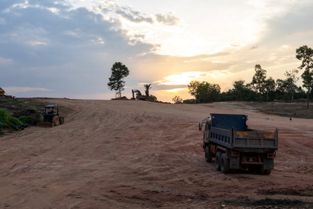 Excavating machinery at the construction site, sunset in background.の写真素材