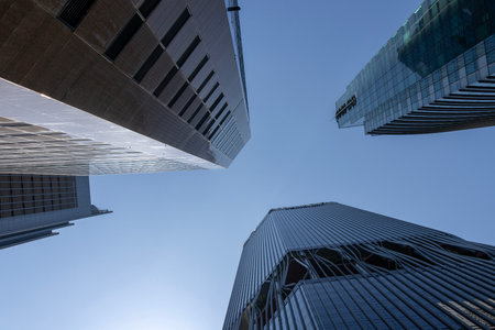 Looking up modern high-rise office buildings with blue sky in the background.