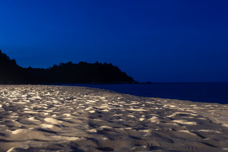 View of Teluk Cempedak Beach at night in Kuantan, Malaysia. Teluk Cempedak Beach is known for its clear blue waters and fine white sandy shoresの写真素材