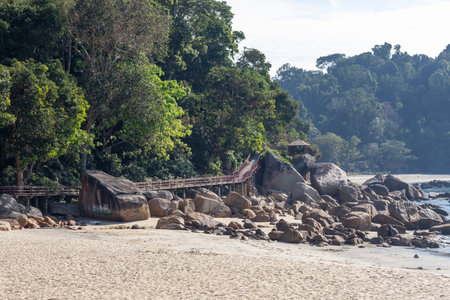 Telok Cempedak Beach in Kuantan, Malaysia. It is a tropical beach with red rocks formed by the tide, stones and plantsの写真素材