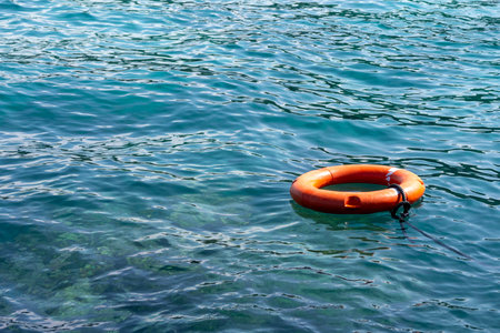 Orange lifebuoy floats on the ocean. Security concept.の写真素材