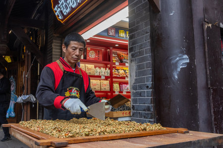 Chongqing, China- 10 Nov 2025: Workers prepare the local snack at Ciqikou Ancient Town in Chongqing, China. The old town has been rejuvenated and turned into a tourist attractionのeditorial素材