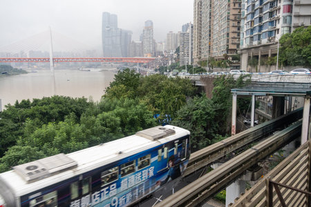 Chongqing, China- 7 Nov 2025: Chongqing metro train travel on the high rise track in Chongqing city, China. It serves the transportation needs of the city main business areas and inner suburbs.のeditorial素材