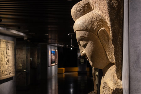 Dazu, China- 6 Nov 2025: Collection of ancient stone craved artwork inside Dazu Stone Carving Museum in Chongqing, China. The museum houses a large number of precious stone carving cultural relicsのeditorial素材