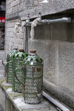Hot water is being collected from tab duing the old times in Chongqing, China.の写真素材