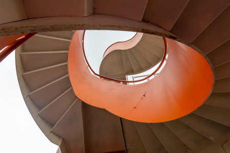 Spiral staircase with bright orange and white color.