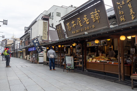 Tokyo, Japan- 27 Dec 2025: Shops along Taishakuten Sando at Shibamata, Tokyo. It is a street filled with shops selling hot snacks, offering an authentic cultural experienceのeditorial素材