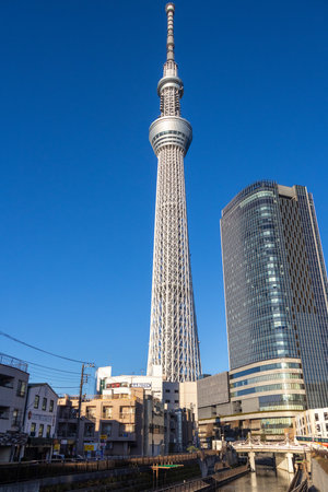 Tokyo, Japan- 17 Dec 2025: Amazing structure of Tokyo Skytree with blue sky. Skytree soars 634...