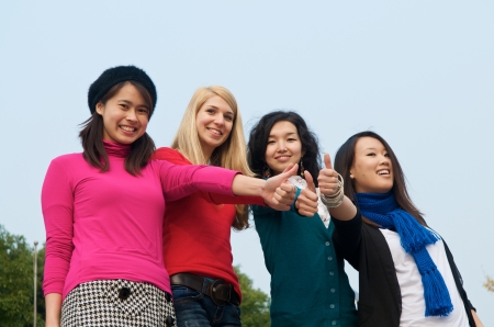 Group of 4 female students outdoor thumbs upの写真素材