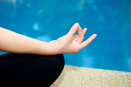 Yoga Meditation hand by pool, lotus pose (padmasana)の写真素材