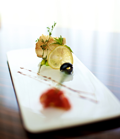 Sea bass canapÃ© with lemon on white plateの写真素材