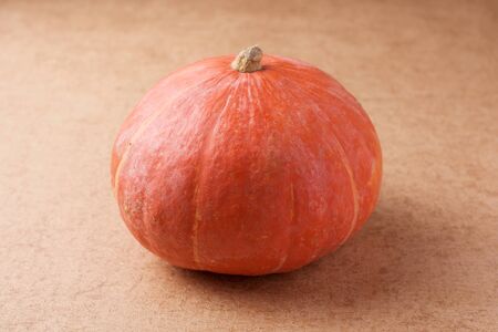 Orange Pumpkin on light brown backgroundの写真素材