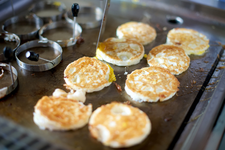 Fried eggs on a grill in restaurantの写真素材