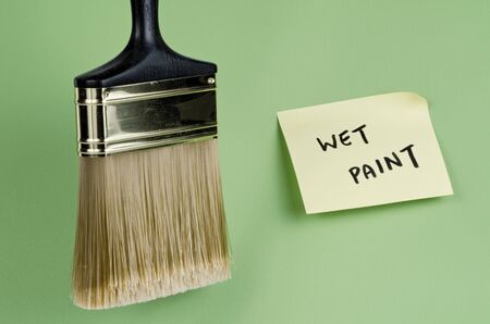 Paint apparatus against brightly colored wall with sign 