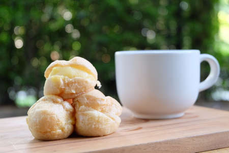 Cream puff with a cup of tea for a relax dessert in the green gardenの写真素材