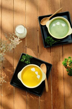 Healthy breakfast with Pumpkin and Spinach Soup on wood table with warm garden light  shadowsの写真素材
