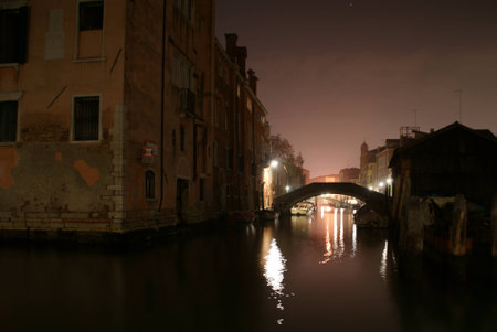 Bridge on a canal in Venice at nightの写真素材