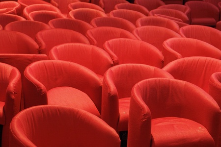 Rows of red seats, some aligned, some disorderly placedの写真素材