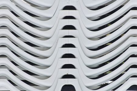 A pile of white flat beds viewed from side resulting in a abstract curves and lines effectの写真素材