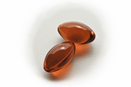Two red colored pills on a white background